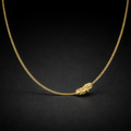 Gold necklace with a lion head pendant on a black background