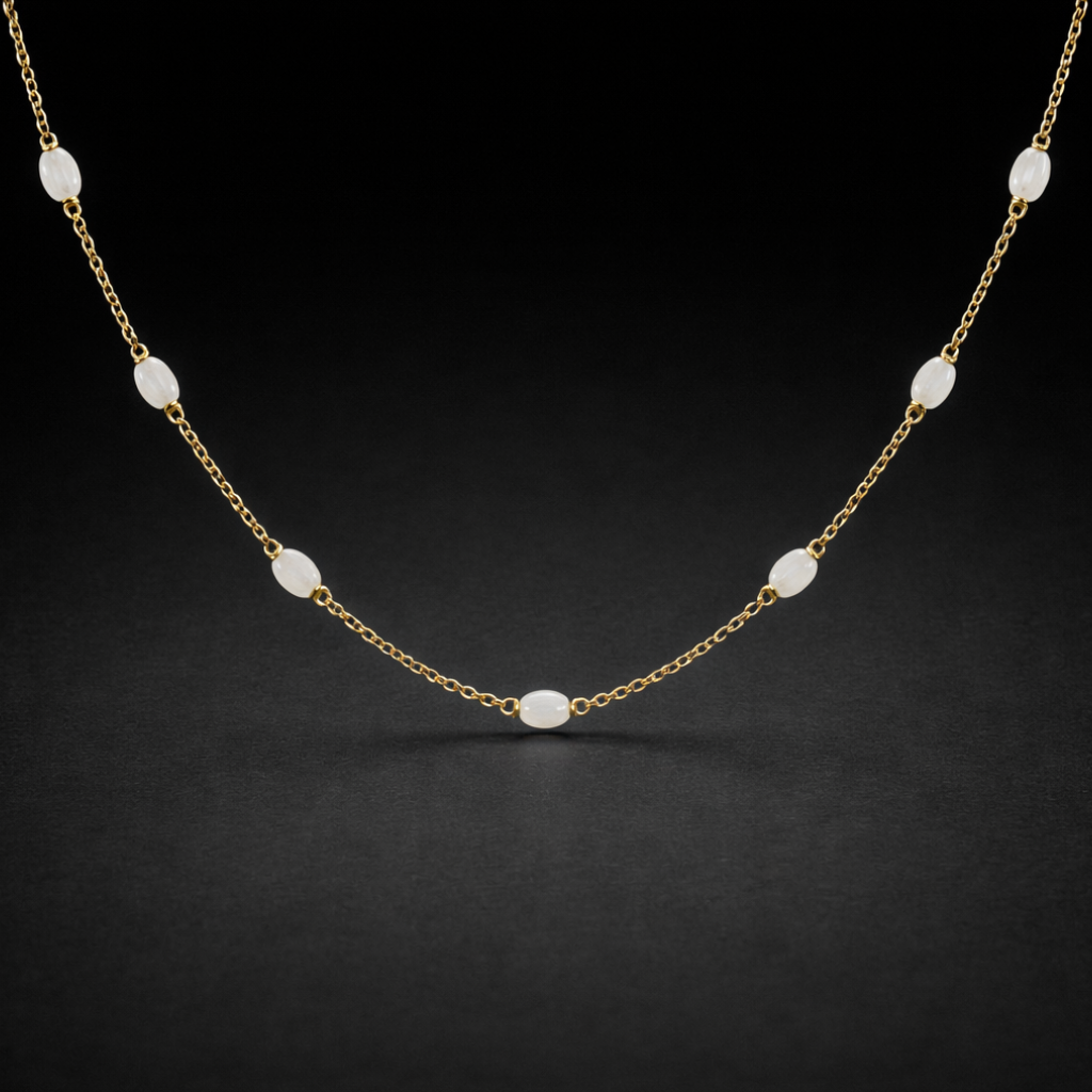 Gold necklace with white beads on a black background